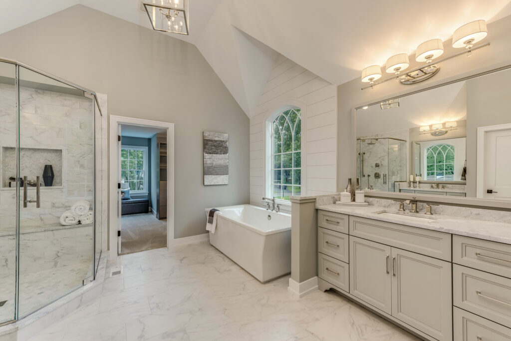 Luxury bathroom remodel in Evansville, Indiana featuring a freestanding soaking tub, marble shower, and double vanity.