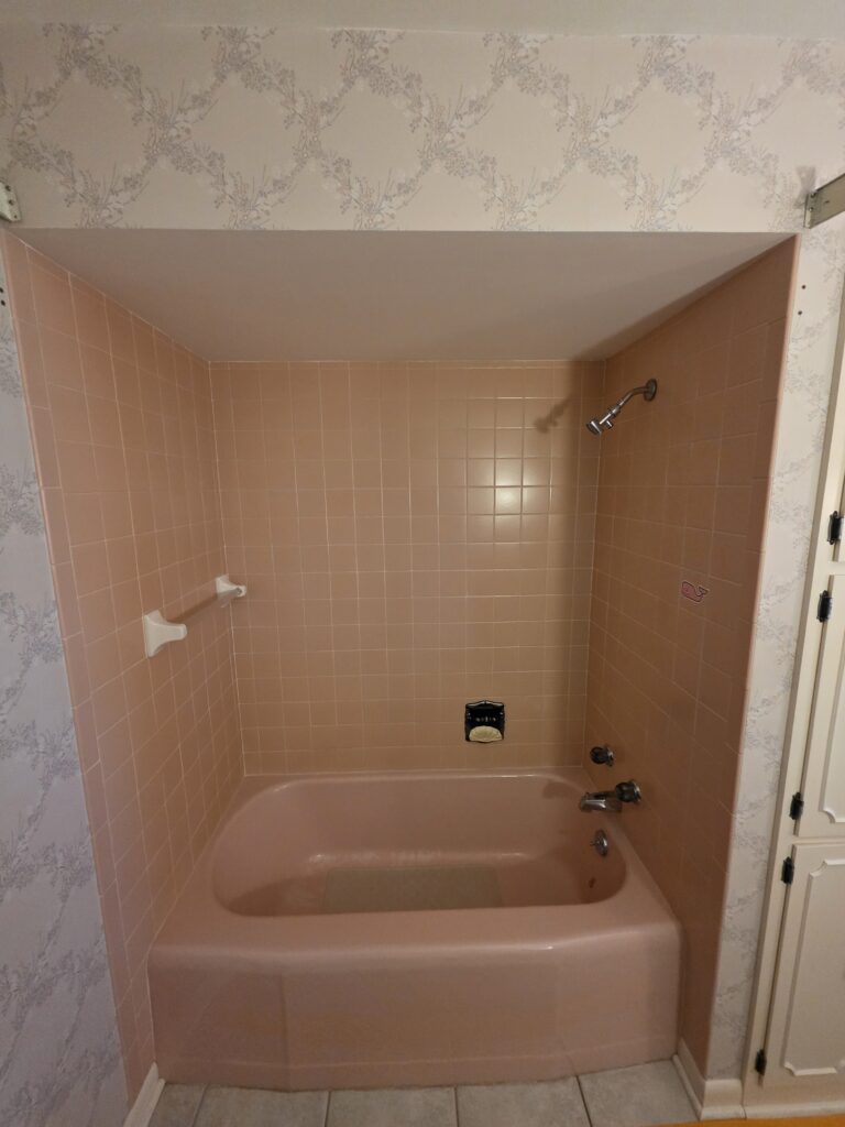 Before bathroom remodel in Haubstadt Indiana showing outdated pink tub and tile surround prior to demolition