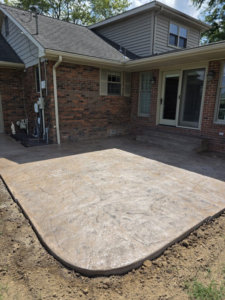 Stamped concrete patio installation behind brick home in Haubstadt, Indiana